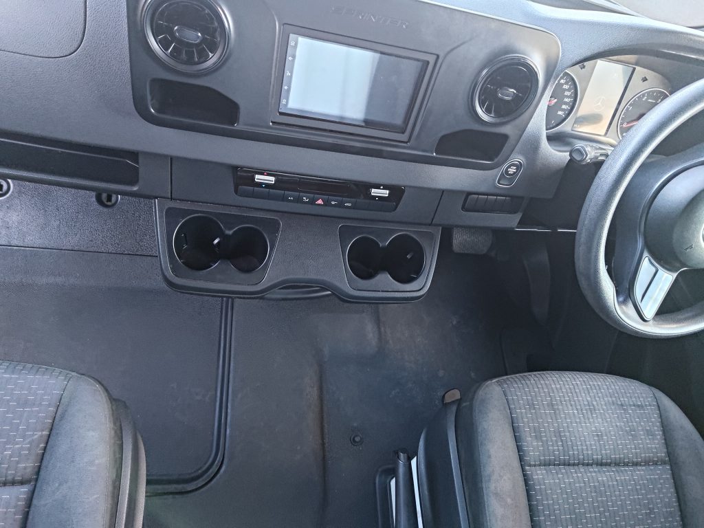 Original Mercedes Sprinter dashboard and factory infotainment setup before the Mobile Dojo workstation upgrades.