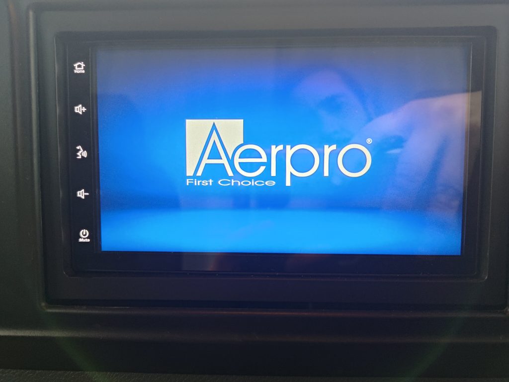 Aerpro infotainment head unit powering on during installation in the Mercedes Sprinter dashboard.