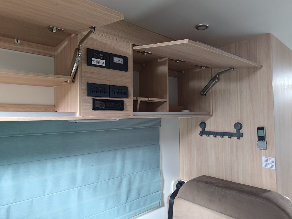 Overhead storage cabinets inside the Mobile Dojo with compartments opened to show organised interior storage.