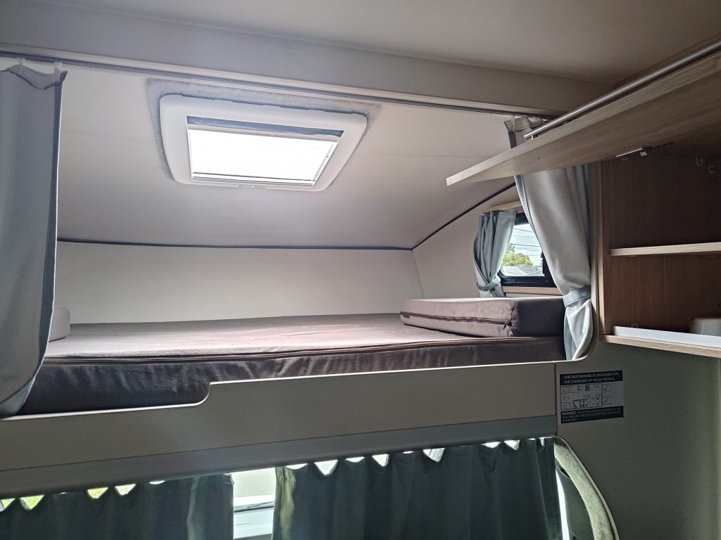 Sleeping area inside the Mobile Dojo showing the upper bed and compact interior layout designed for long-term travel.