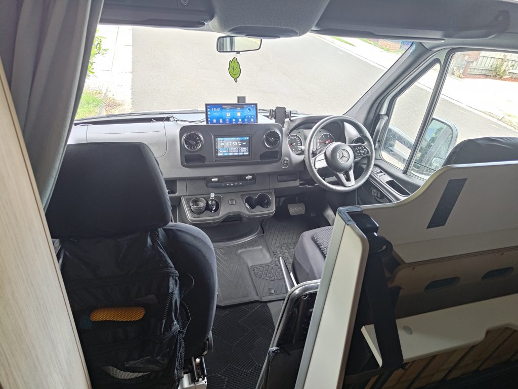 Interior view of the Mobile Dojo showing the front cab workstation from the living area.
