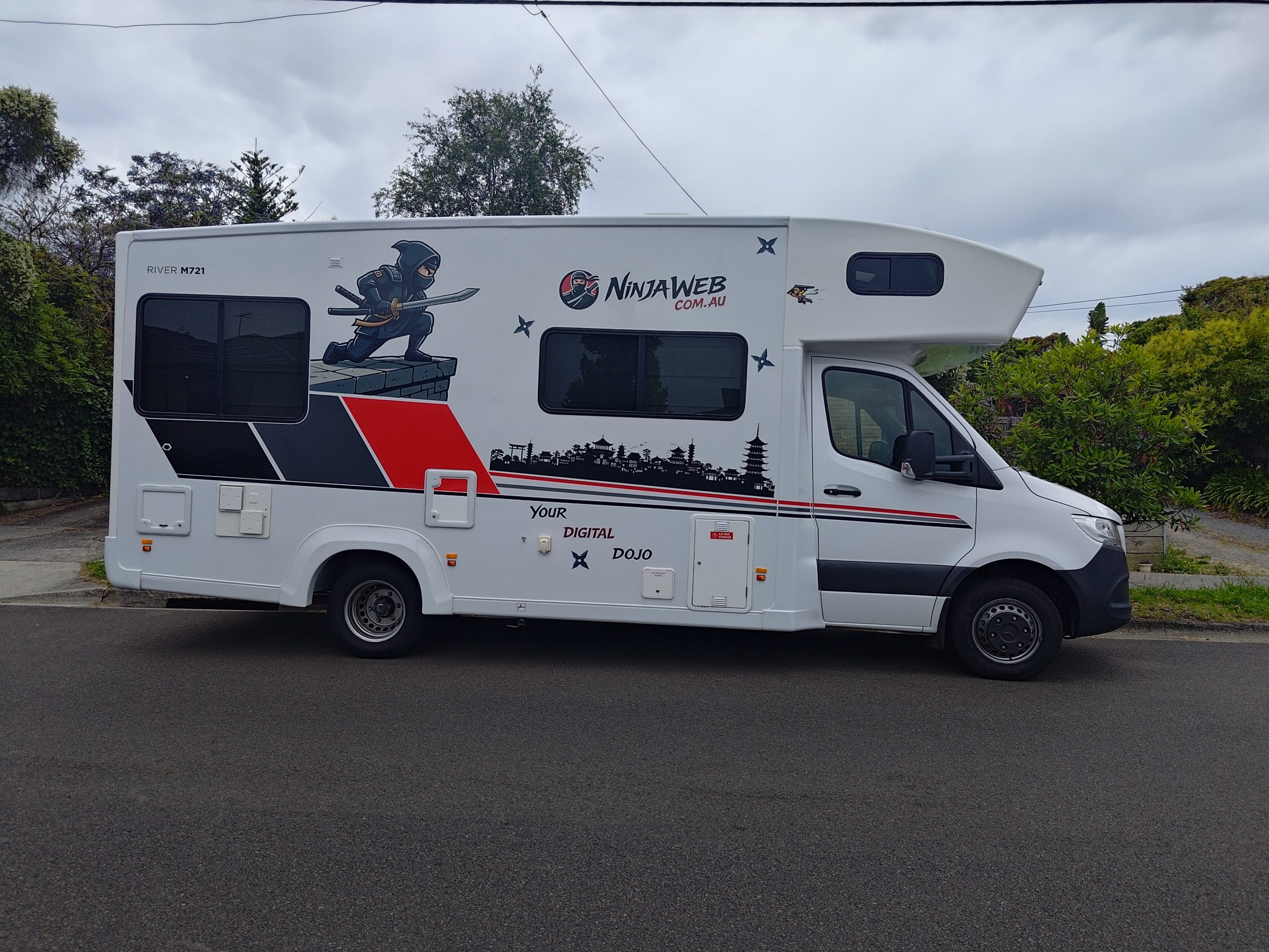 Full side profile of the Mobile Dojo featuring the completed NinjaWeb wrap and visual identity.