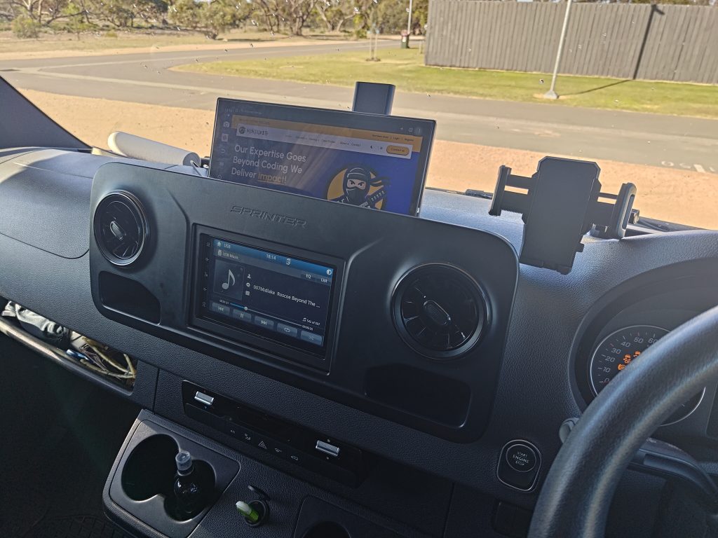 Driver’s view of the Mobile Dojo workstation setup with dashboard infotainment and mounted secondary display.