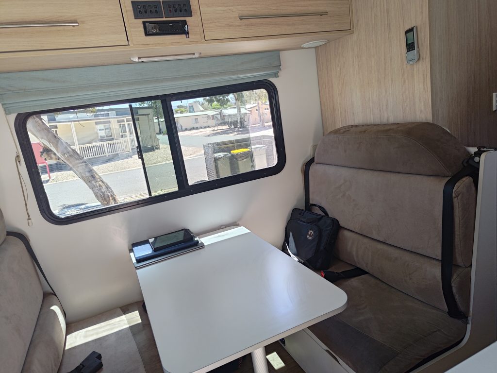 Mobile Dojo dinette area configured as a clean workspace, showing seating, table, and natural light from the side window.
